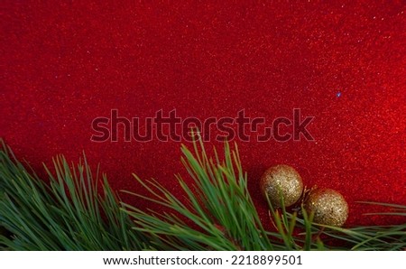 Red Christmas background with Christmas tree branch and Christmas balls and toys                            