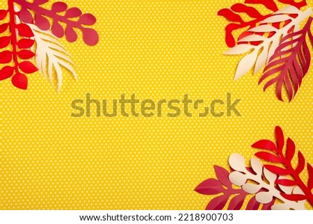 Yellow paper background with white polka dots and white and red paper flowers