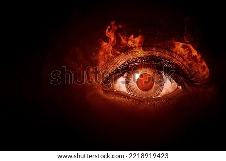 Close up of human eye with fire flames in dark background