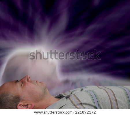 Male lying supine with eyes closed and astral projection effect on dark background Royalty-Free Stock Photo #221892172