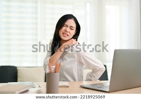 Beautiful young Asian businesswoman suffering from shoulders and back pain after had a long day at work. overworked, office syndrome concept Royalty-Free Stock Photo #2218925069