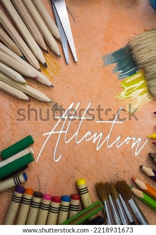Overhead shot of school supplies with Attention text. Brushes, pencils, artistic tools. Art And Craft Work Tools.
