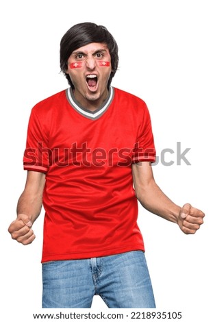 Soccer fan man with jersey and face painted with the flag of the Switzerland team screaming with emotion on white background.