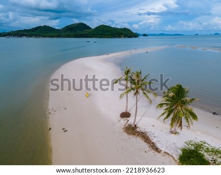 couple men and women walking on the beach at the Island Koh Yao Yai thailand, beach with white sand and palm trees