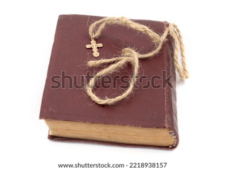 a golden cross is lying on an old church book