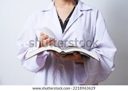 	
Doctor scientist in white coat turning the page of an open book. Knowledge, learning, study concept.