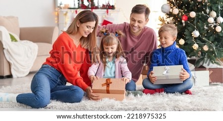 Happy family opening Christmas gifts at home