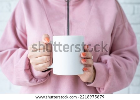 closeup woman hands in pink clothes holding white mug for mockup design