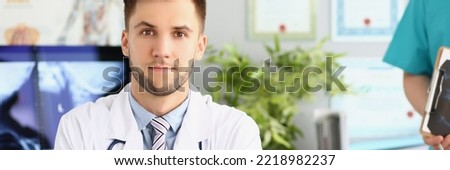 Young qualified medical worker in hospital, first day at work, young male specialist in medicine