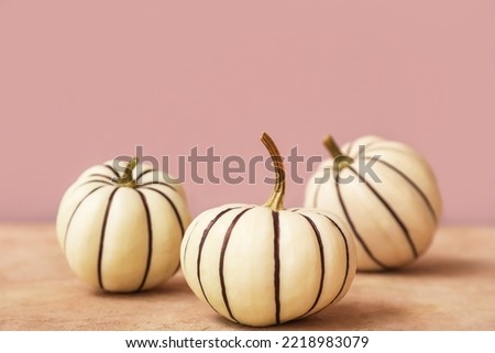 Painted Halloween pumpkins on color background