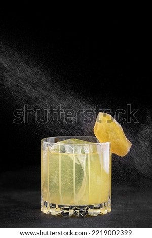Penicillin cocktail in an old fashioned glass on dark concrete Royalty-Free Stock Photo #2219002399