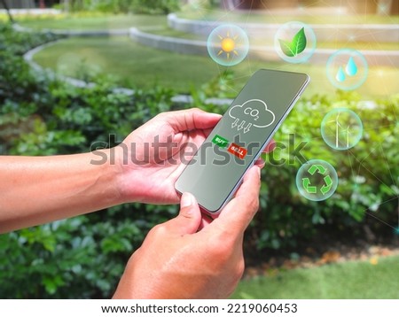 Man use smartphone to trade carbon credits on stock market with eco friendly icon. Renewable energy sustainable development.  