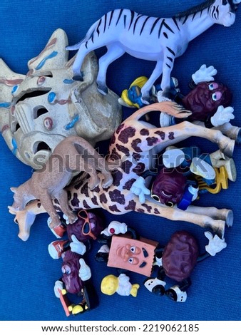 Pile of animal toys on a solid blue background