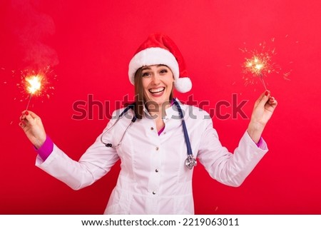 A female doctor congratulates patients on the new year. Doctor with sparklers on a red background