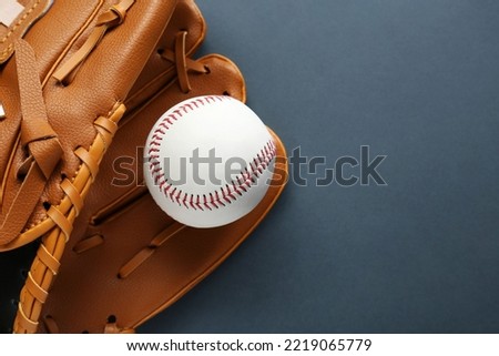 Catcher's mitt and baseball ball on dark background, top view with space for text. Sports game