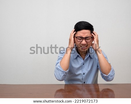 Asian businessman feels headache sit at table Royalty-Free Stock Photo #2219072173