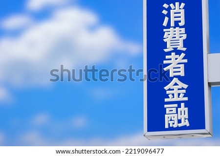 A sign with the words "Consumer Finance" in Japanese and a blue sky.