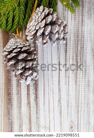 
Rustic Christmas background with pine leaf and pinecones on whitewashed wooden surface with copy space
