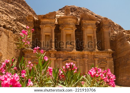Oleander bush and the facade of the Monastery, one of the famous monuments of the ancient Nabatean city of Petra, Jordan. Royalty-Free Stock Photo #221910706