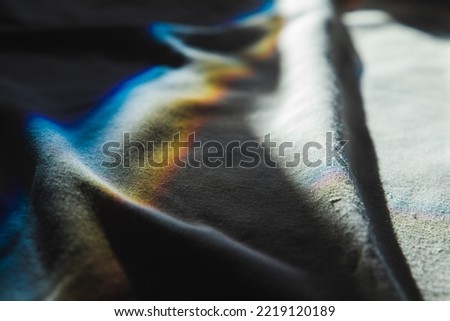 Sunbeams with soft spectrum colors go over white fabric, physical refraction effect. Abstract photo background