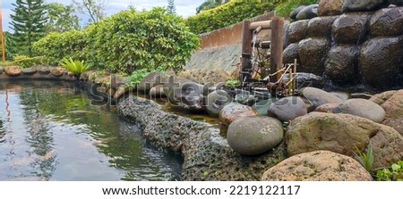 Jakarta, Indonesia, October 27, 2022, a waterwheel beside a fish pond