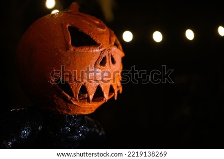 Pumpkin head monster Halloween decoration in darkness. Scary monster head with sharp teeth