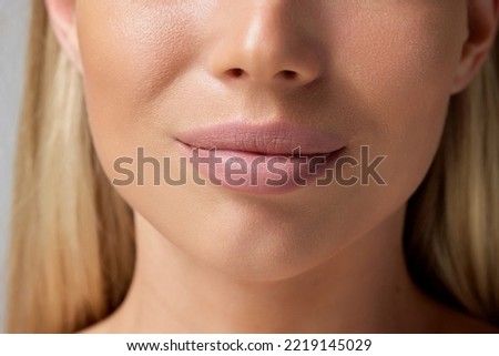 Cropped close-up image of plump female lips, perfect chin isolated on grey background. Cosmetology injection. Concept of beauty, natural skin, cosmetology, spa, plastic sugery. Copy space for ad Royalty-Free Stock Photo #2219145029