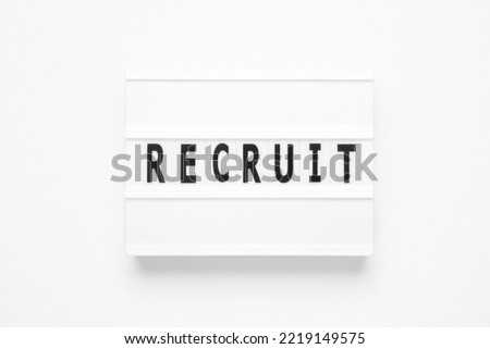 Lightbox with word RECRUIT on white, searching for people, recruitment concept
