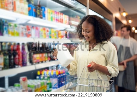 An African american woman buy a bottle of milk from refrigerator cold in convenience store for drink at home Royalty-Free Stock Photo #2219150809