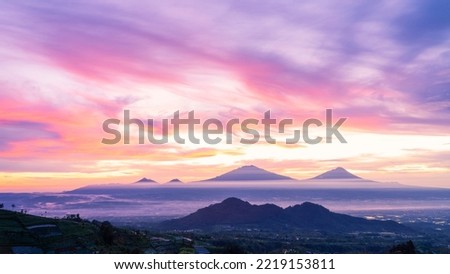 Beautiful dramatic reddish orange sunrise sky with mountain range - Merapi Volcano, Merbabu, Telomoyo and Andong Mountain