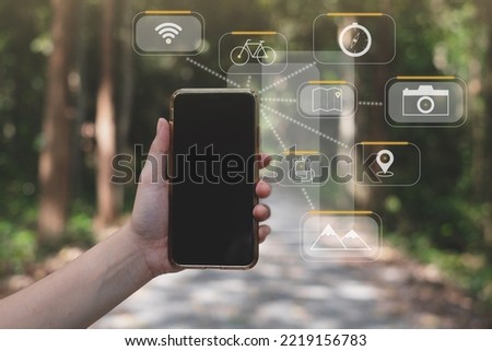 Concept of Travel amoung nature with technology. A traveler is using internet, wifi, wireless mobile phone to search. Concept of doing leisure activity with smart phone. Black screen display explore.
