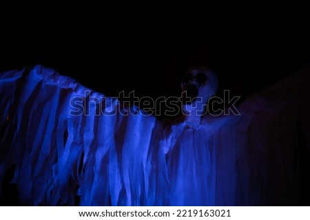 Halloween ghost decoration, scary red scream face costume installation in darkness 