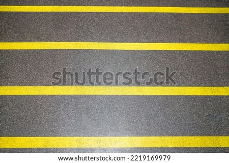  Dark brown cement floor wrapped with yellow tape for the background.                              