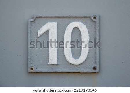 Old retro weathered cast iron plate with number 10 closeup
