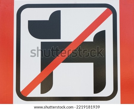Close-up photo of a sign with a dog crossed out in red announcing a prohibited area for no dogs in a public park