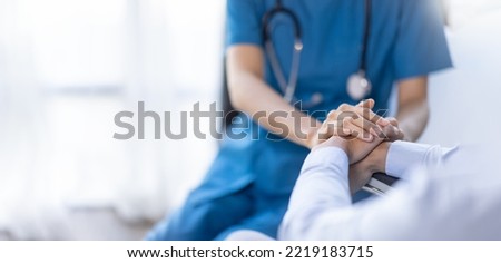 Cropped shot of a female nurse hold her senior patient's hand. Giving Support. Doctor helping old patient with Alzheimer's disease. Female carer holding hands of senior man Royalty-Free Stock Photo #2219183715