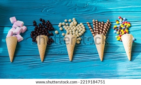 Ice cream cones with colorful candies, cookies, and chocolate balls