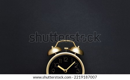 Golden vintage alarm clock on a black background. Black Friday time. Selective focus, copy space