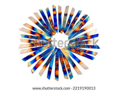 utility knife blades, heated in the fire arranged in the form of sun rays on white background, Psychedelic colors