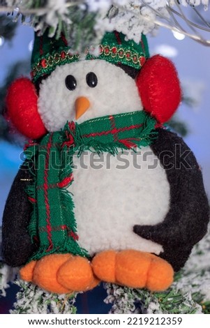 Christmas penguin doll on a snowy christmas tree