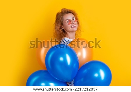 party woman with balloon in sunglasses. positive woman hold party balloons in studio.