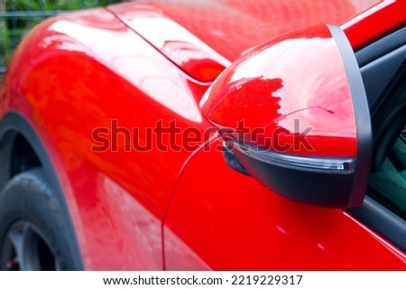 Close up of red car wing mirror.