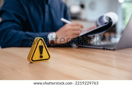 Warning sign on table in front of businessman Caution in investing Economic situation warning, Deflation and  inflation concept money saving for retired and office syndrome also.