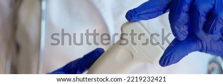 Doctor prepares ultrasound machine for diagnosing patient. Doctor holds ultrasound probe closeup Royalty-Free Stock Photo #2219232421