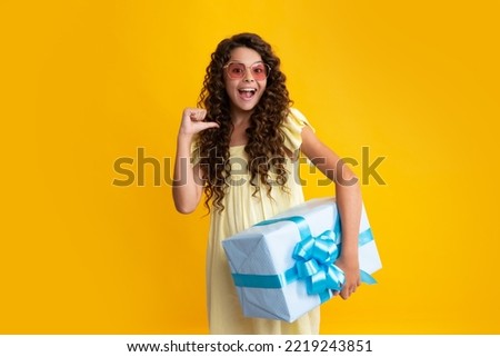 Happy teenager, positive and smiling emotions of teen girl. Child with gift present box on isolated studio background. Gifting for kids birthday.