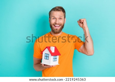 Photo of hooray beard guy hold house yell wear orange t-shirt isolated on teal color backgroiund