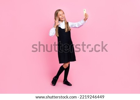Full length photo of nice positive cheerful girl blond hairdo uniform making selfie on smartphone isolated on pink color background