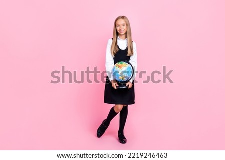 Full size photo of intelligent good mood girl straight hairdo school uniform hold globe world map isolated on pink color background