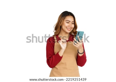 Coffee shop SME owner excited brunette asian woman wearing sweater and apron isolated on white background, Using mobile