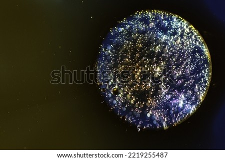 Abstract background with liquid and drops over a blurred backdrop, close up.